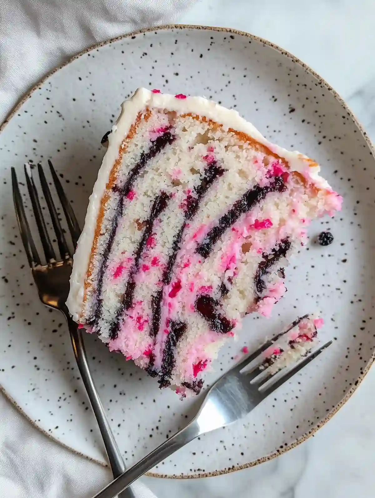 Cherry blossom cake slice with pink and brown swirls on a speckled plate