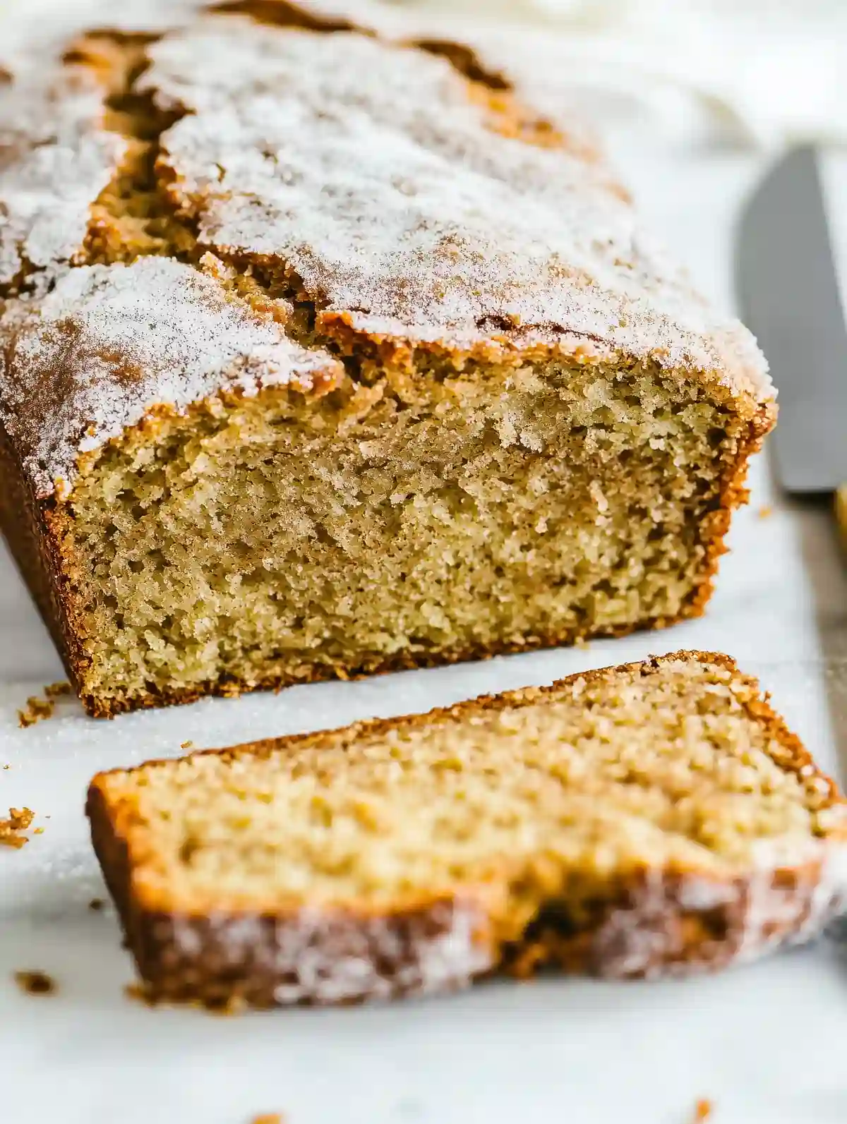 Freshly baked cinnamon bread with golden crust and fluffy interior slices.