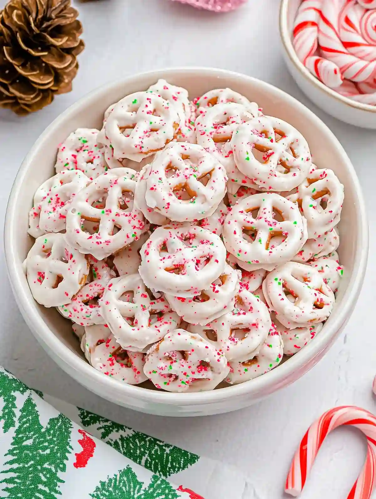 White bowl with chocolate pretzels, peppermint topping, on marble surface