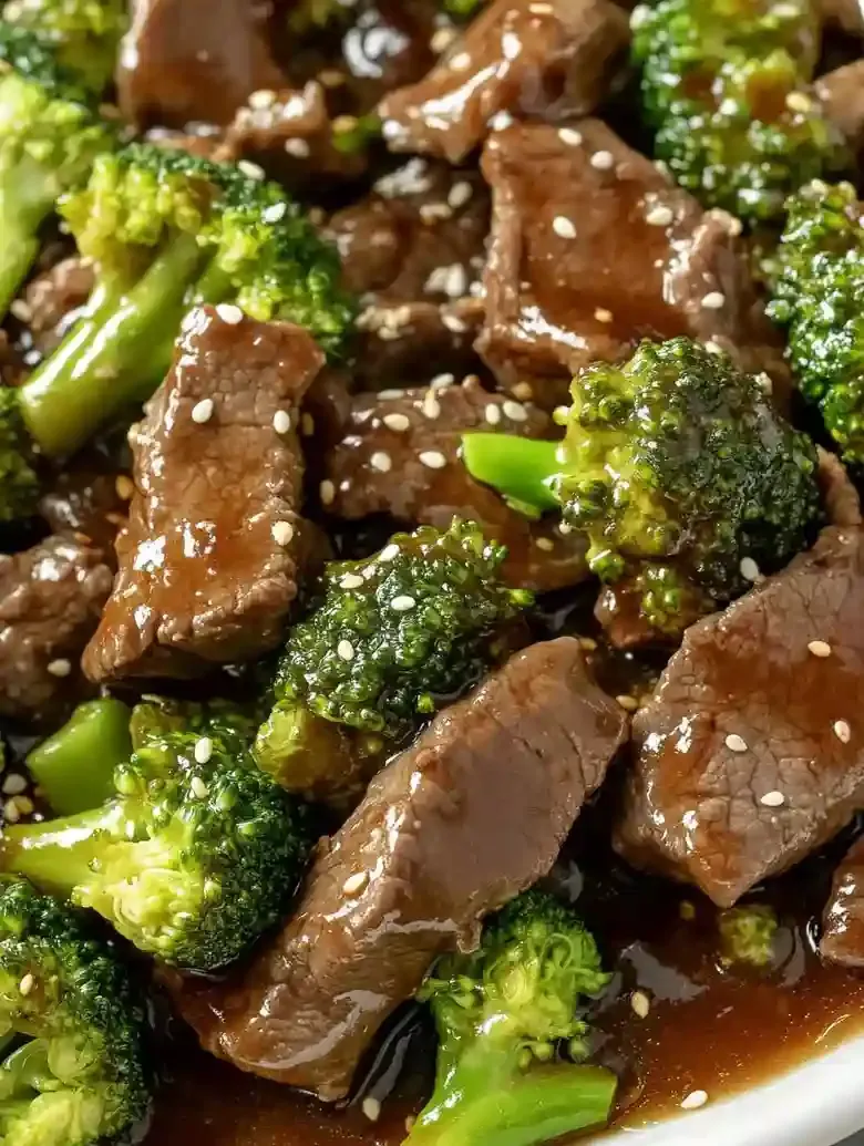 Beef and broccoli in savory sauce, garnished with sesame seeds.