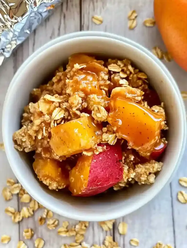 Bowl of diced chicken coated in syrup, topped with crunchy oats.