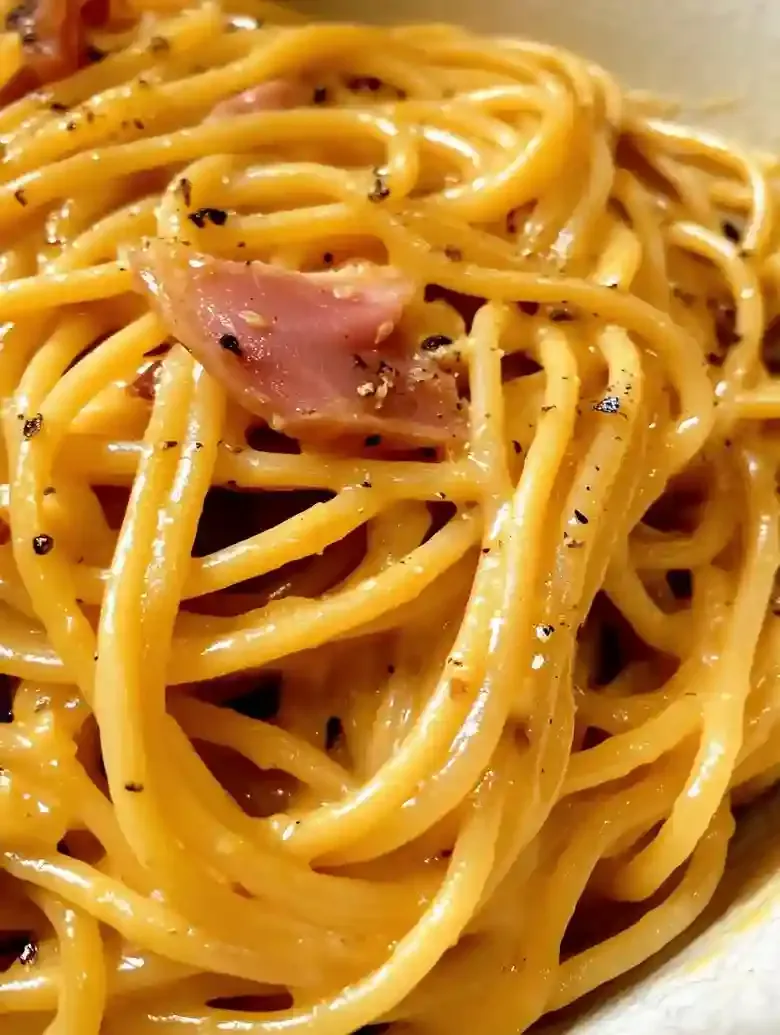 Bowl of spaghetti alla carbonara with guanciale and black pepper.