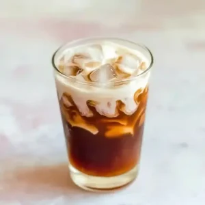 Layered vanilla salted cream cold brew with caramel and sea salt on marble.