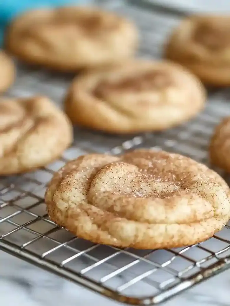 Cream cheese Snickerdoodles on a wire rack, dusted with cinnamon sugar.